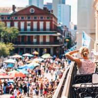 A woman overlooking a parade in the french quarter